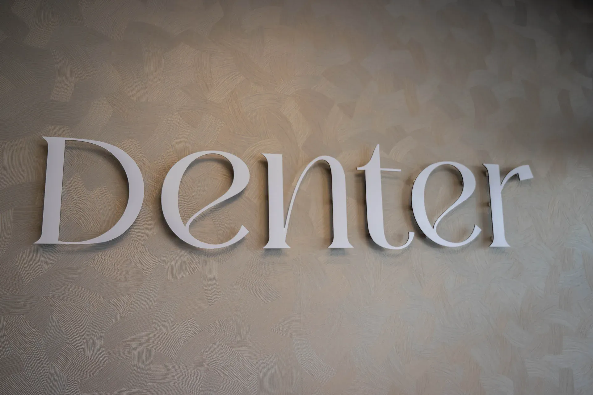 Logo van DENTER op de wand van de wachtkamer