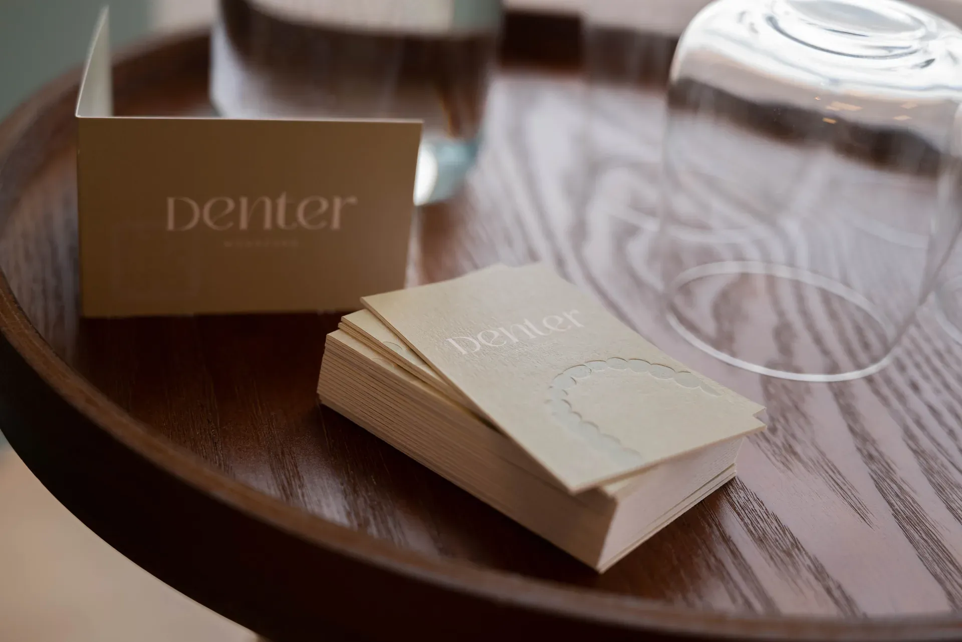 Visitekaartjes van DENTER mondzorg op een houten dienblad